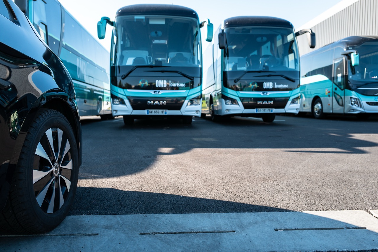 Autocars OMB Tourisme garés côte à côte devant l'entrepôt de l'entreprise